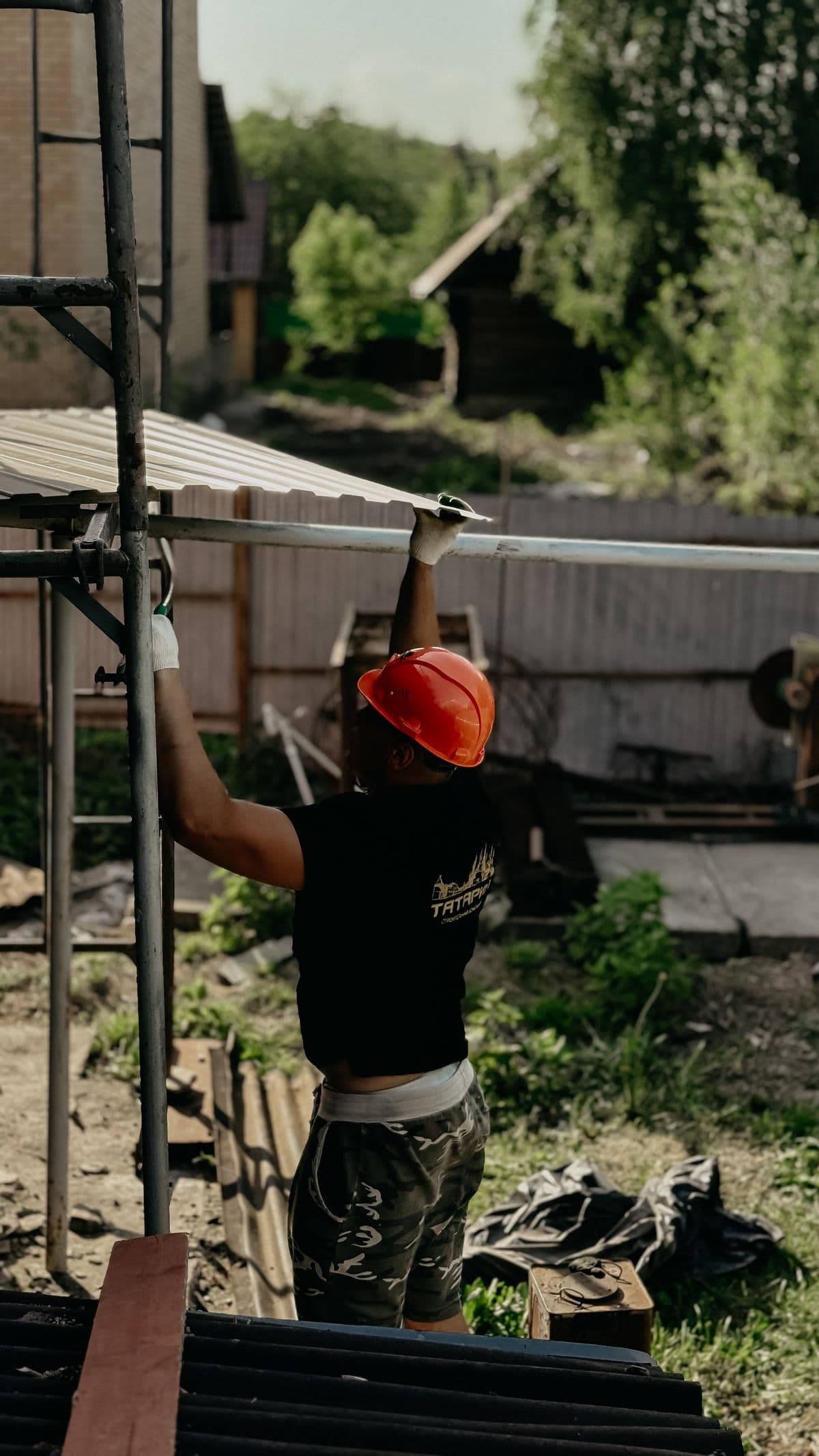 Worker installing roof sheeting on a roof structure